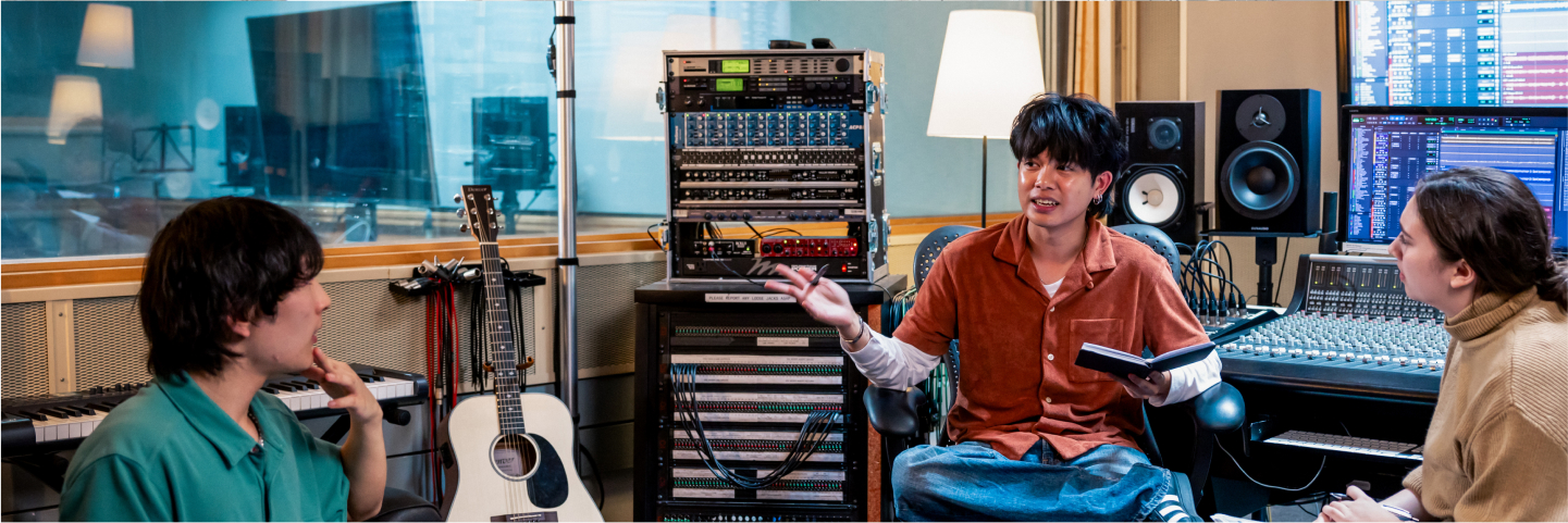 Three students discussing in a music production studio