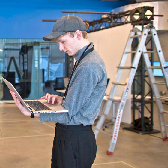 Student on set using a laptop