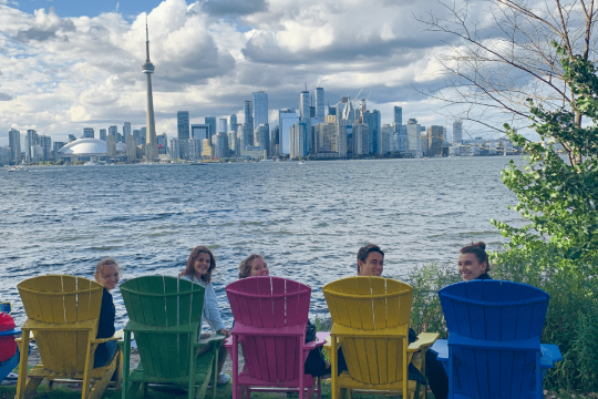 Students smiling seating in the steps of a concrete staircase in Cortona, Italy