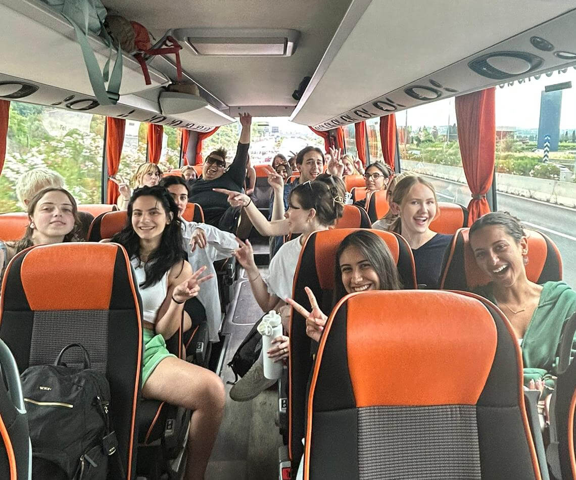 Students on tour bus talking and laughing
