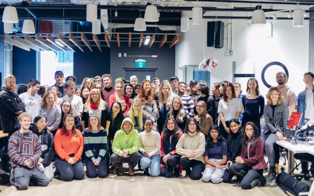 student cohort posing for a year-end class photo at the final showcase of global campus studio