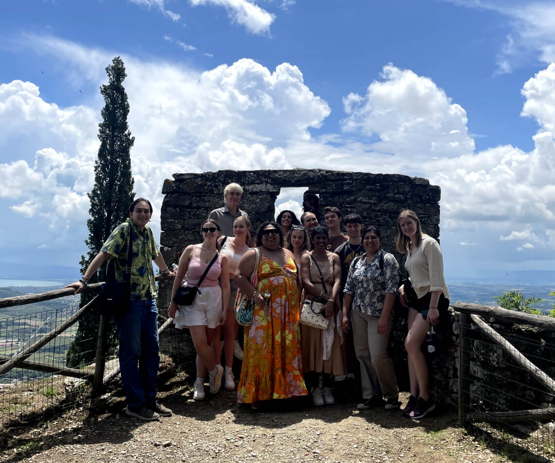 Group of students posing with beautiful sprawling Cortona landscape in the background
