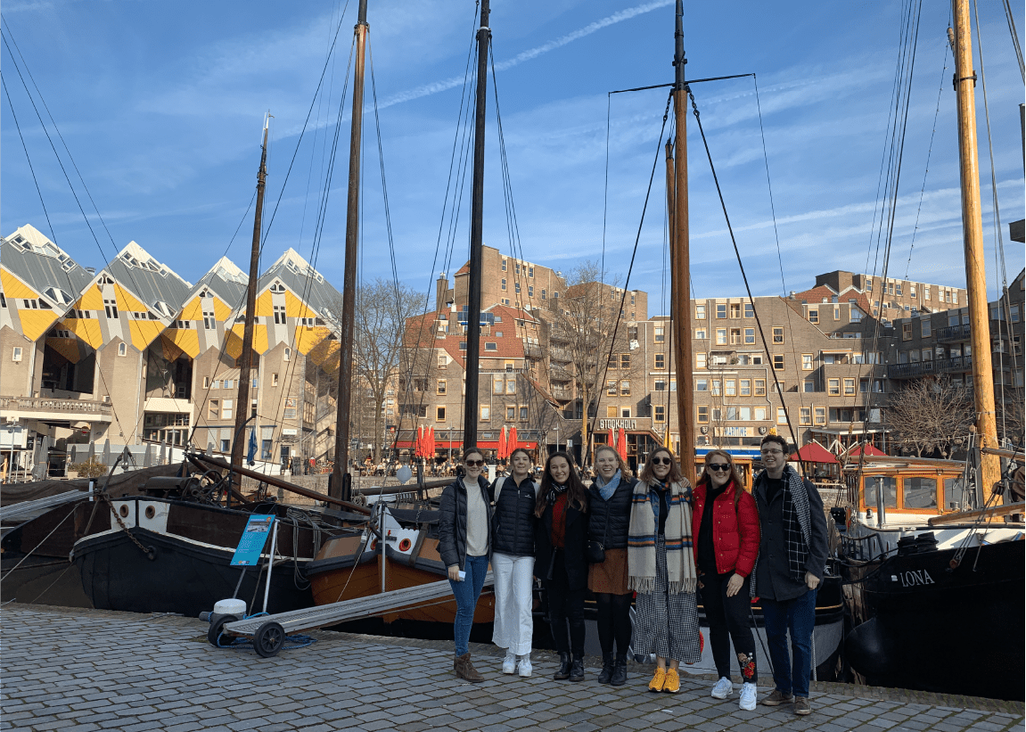Students on exchange in front of ships at harbour 