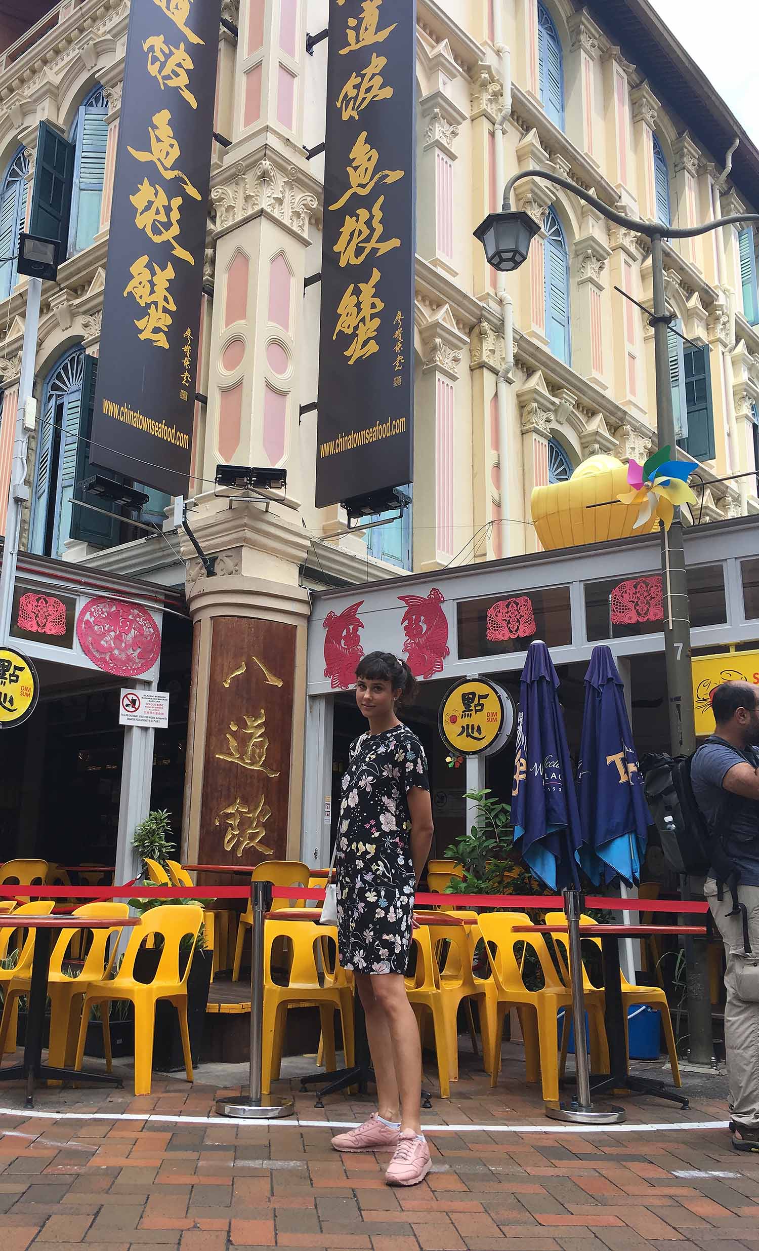 individual wearing a black and white dress posing in front of a building in Asia