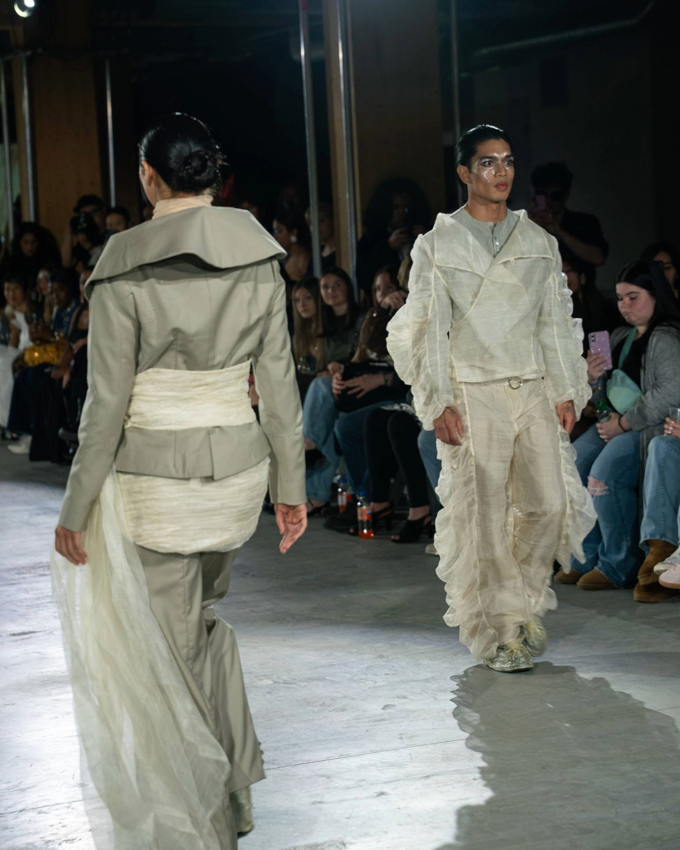 Two runway models shown from front and back, wearing coordinated neutral beige and off-white designs from P. Kirstine Fernandez.