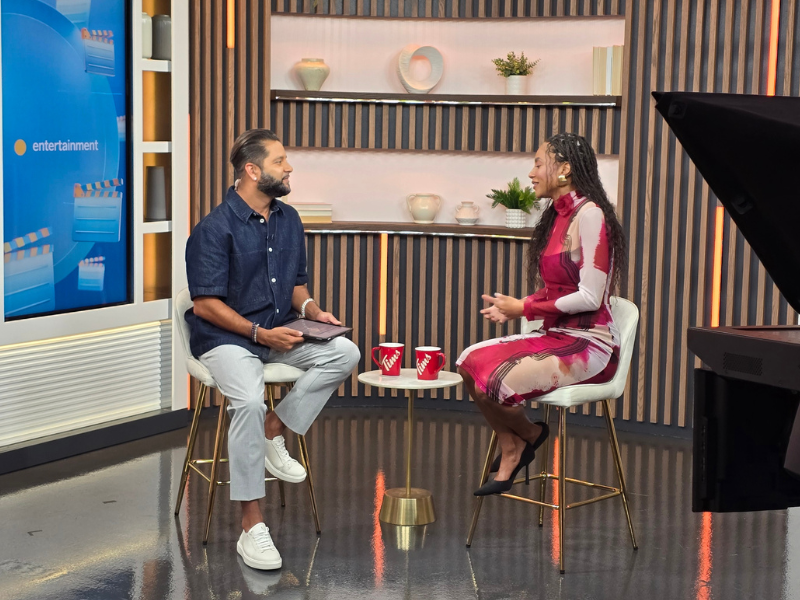 Naomi is on an interview set for Breakfast television. She is sitting down with the interviewer Devo Brown and they are engaged in conversation.