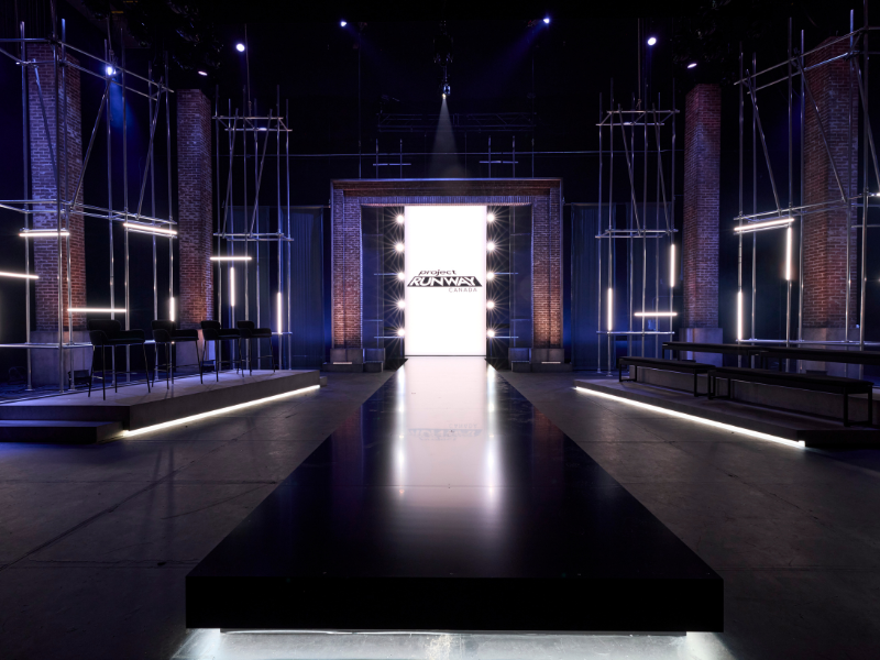 A photo of the Project Runway Canada runway set. Seats are on either side of a runway in the back drown "Project Runway Canada" is written.