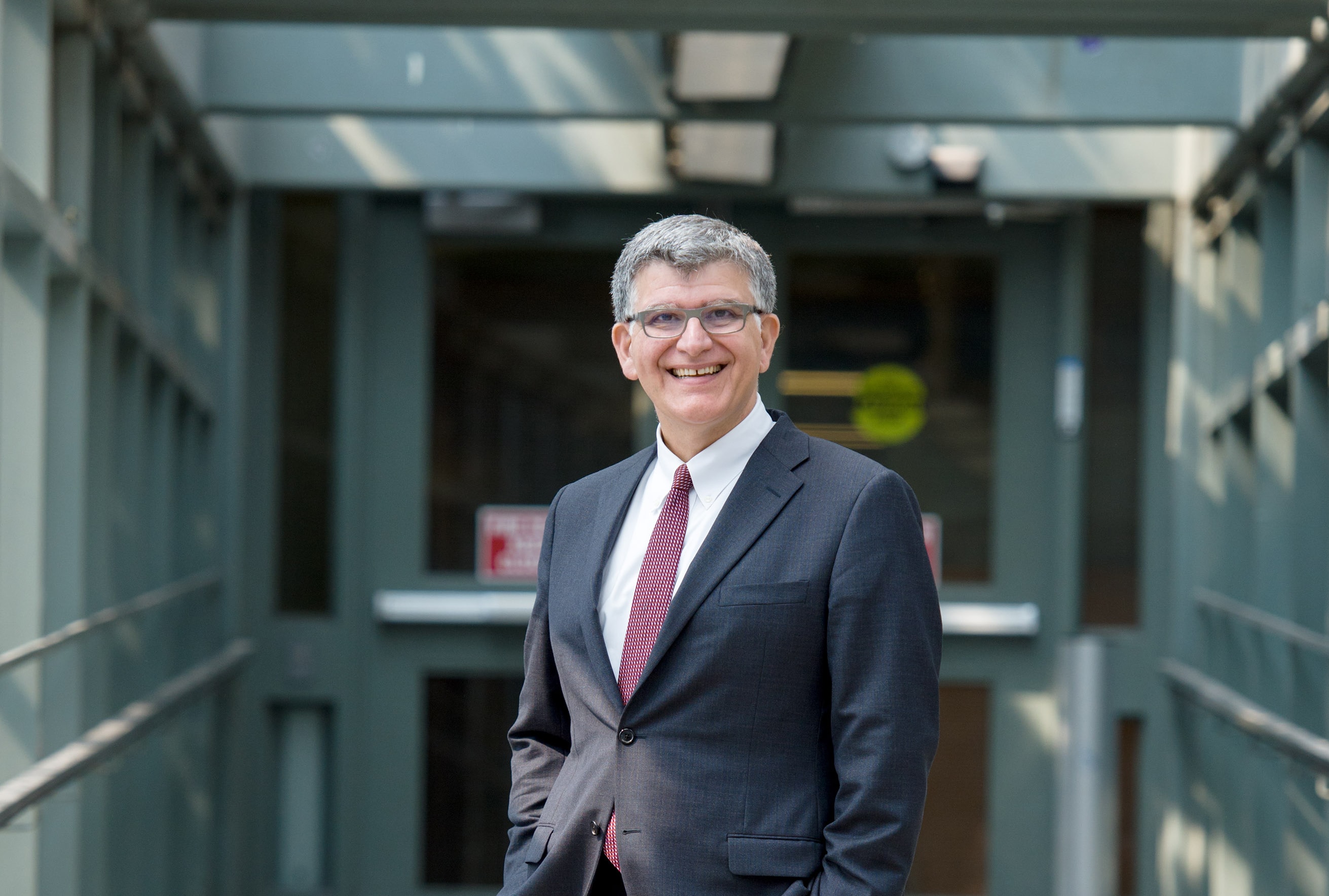 Dean Charles Falzon wearing a suit standing in a hallway