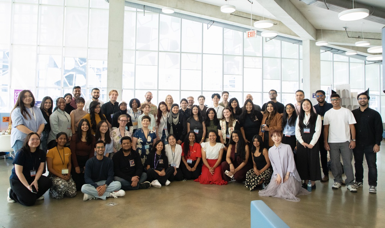 Wide shot group photo of about 50 Master of Digital Media students at Industry Day event.
