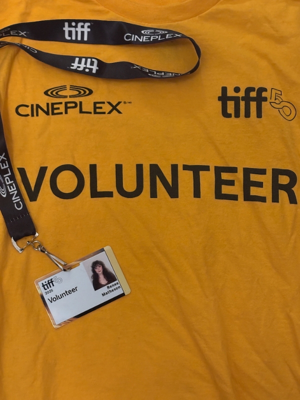  A yellow TIFF volunteer T-shirt with a lanyard and a badge showing the name Renée Matheson.