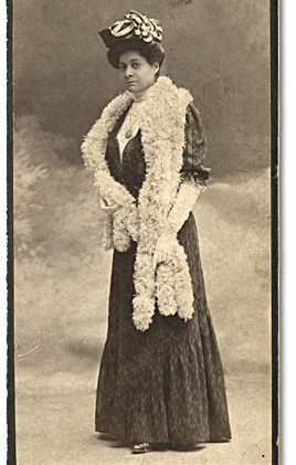 Woman standing in formal attire of the time