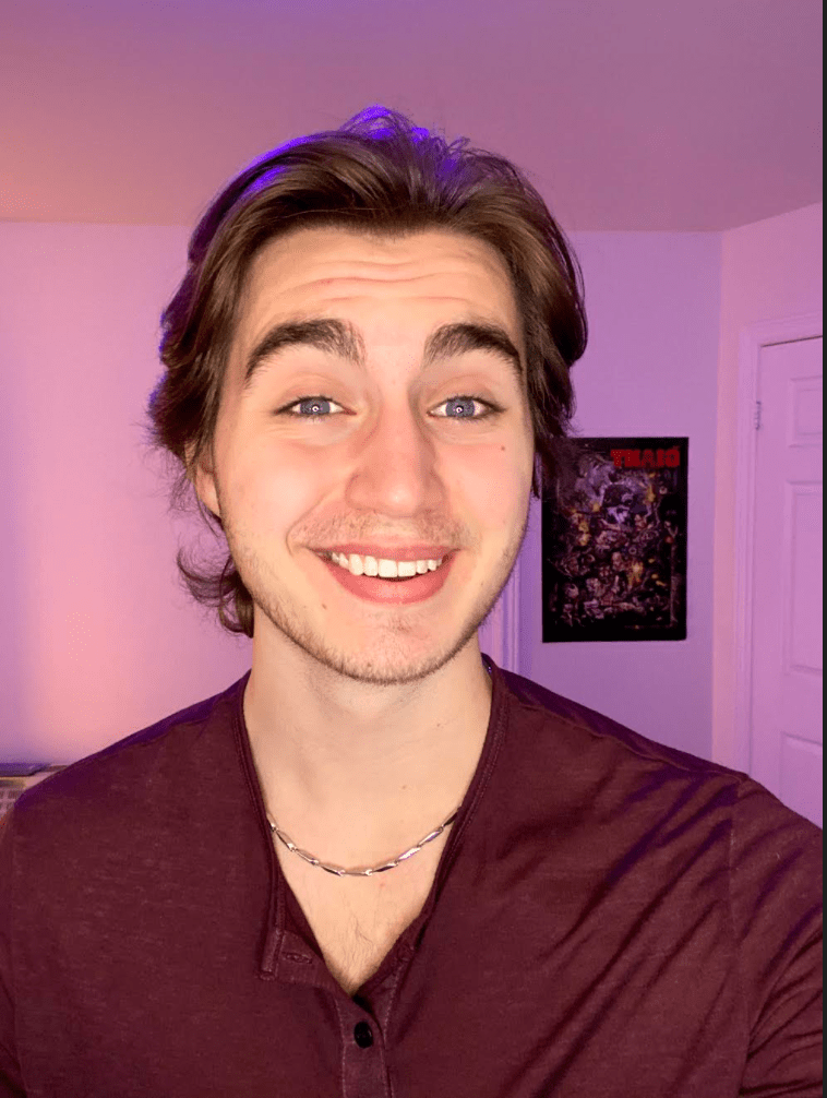 Photograph of Michael Dimuccio. Michael has brown hair and is wearing a maroon shirt. He smiles for the camera. 