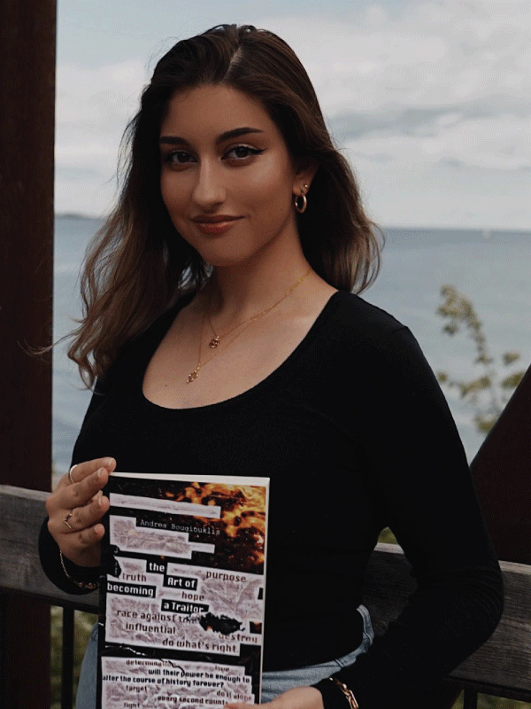 Portrait of author Andrea Bougiouklis posing with a hard copy of her book in her hands