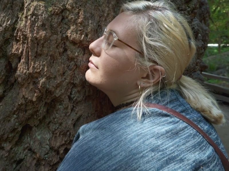 Corrina, daughter of Michelle Melles, hugs tree with eyes closed