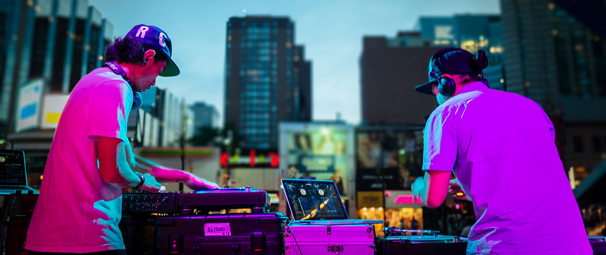 Two men DJ outdoor event in urban environment