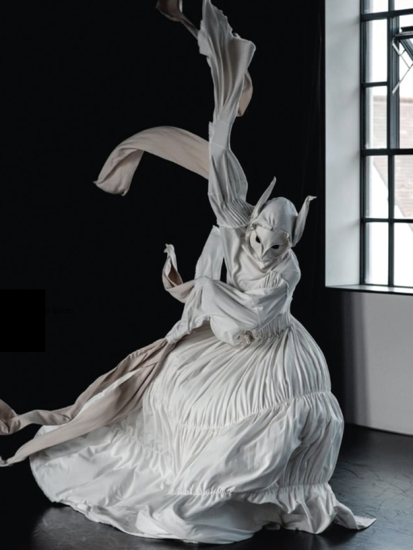 A traditional white full length flowy cloth gown with cut out for the eyes