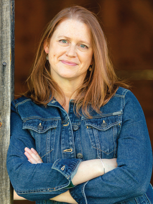 Portrait of author Jennifer Fawcett wearing a blue denim jacket and looking into the camera