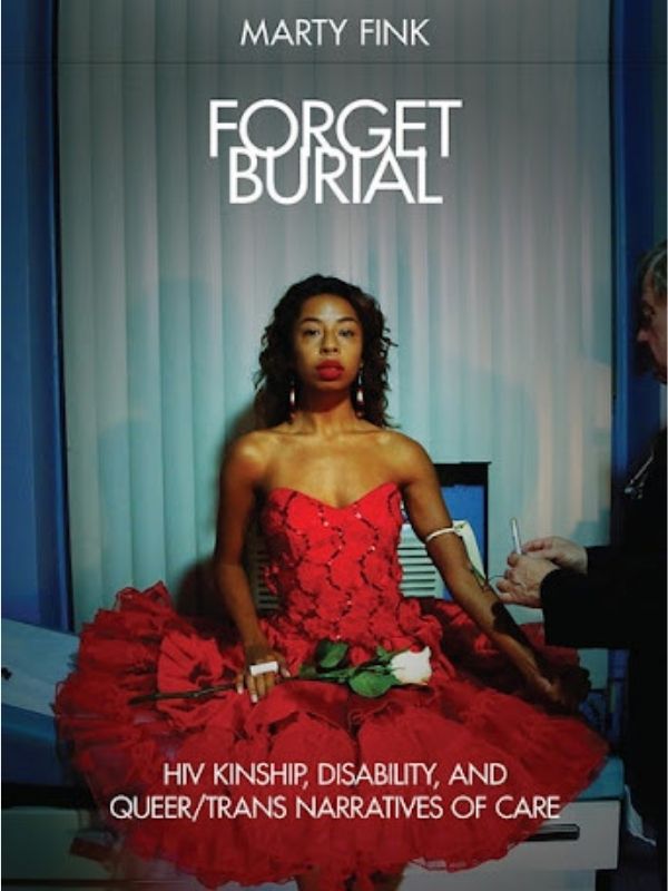 A black person with long hair wears a red dress and holds a white rose. They sit on a doctor’s examination table while receiving blood work and look directly at the camera with a neutral face. 