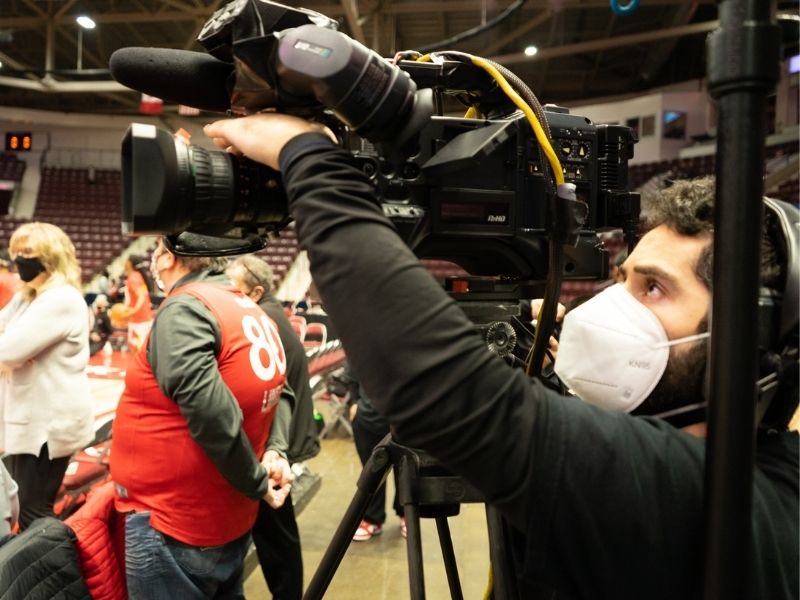 Videographer works camera to capture host for TV