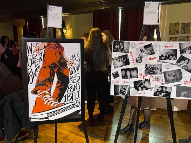 Two art canvases resting on easels. One art piece depicts a person’s lower body wearing bright red jeans and converse. The other features multiple black and white stills.