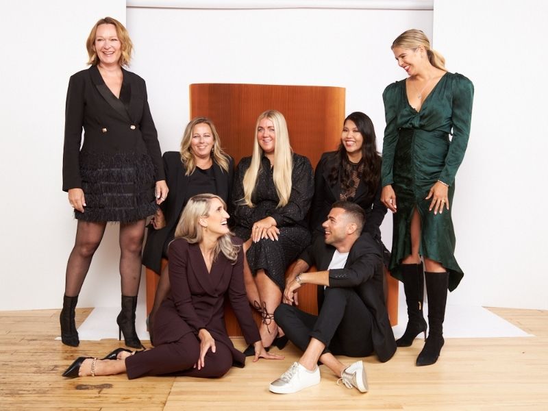 Faulhaber Communications team photo showing men and women posing together in formal attire