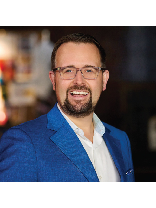 Portrait of co-founder of marblemedia Mark Bishop wearing a blue blazer and glasses