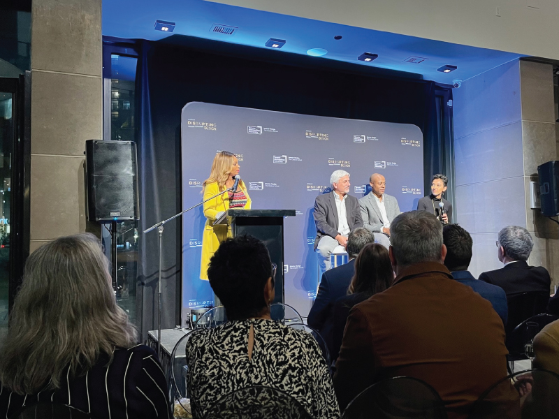 Panelists sit on stage with Tracy Moore