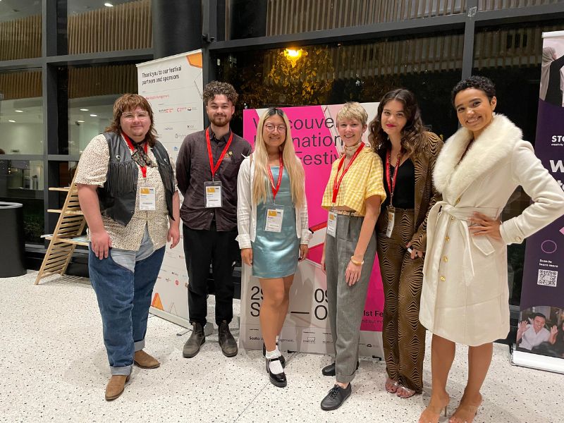 A group of people standing in front of a sign that reads "Vancouver international film festival"
