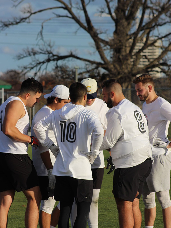 The team huddles with their white jerseys on