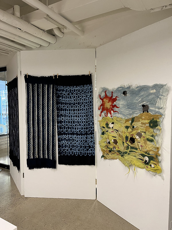 Dyed long fabrics in deep blue colours draped on a wall