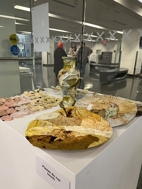 A pot dyed with natural dyes surrounded by fabric pieces on a table