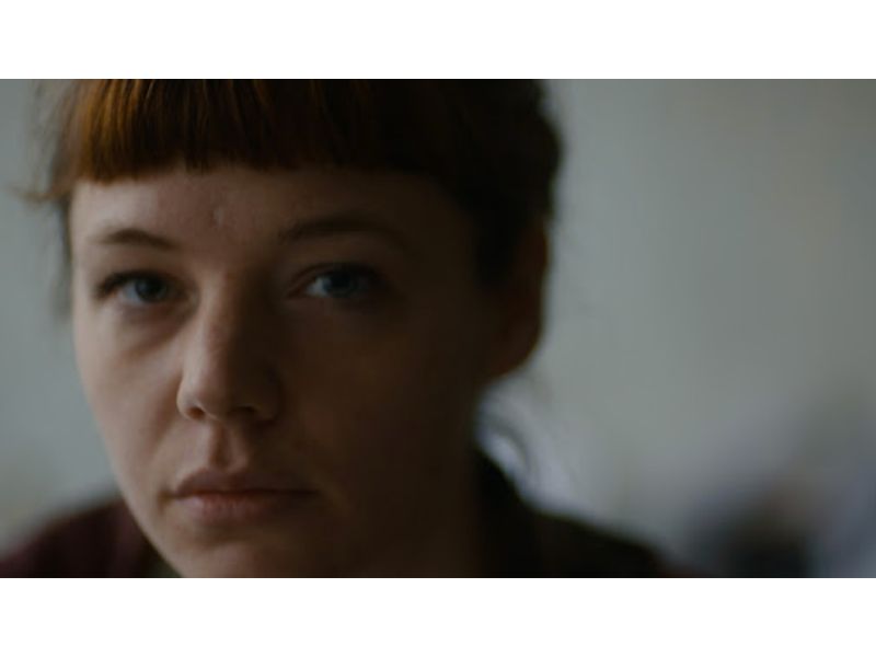 A close up shot of a woman gazing into a camera lens