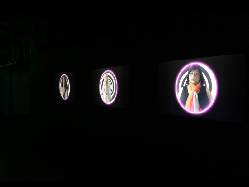 Three circles are projected on a dark wall. Each circle has a person in the center of it.