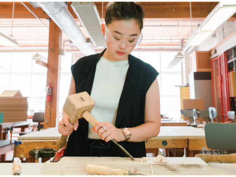 A person uses tools to shave their wood for a project