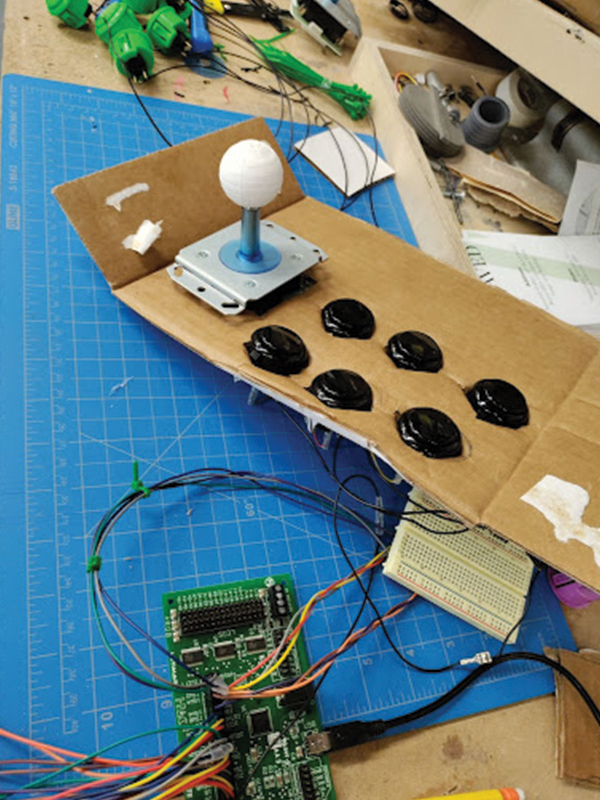 Additional parts of an arcade table are being constructed, including a joystick, buttons and wiring