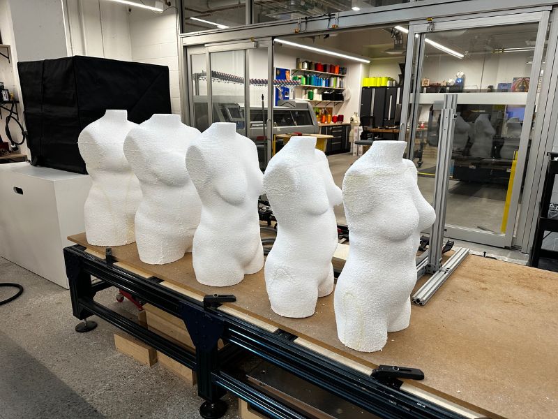 Five body forms made of white foam on a table in the Design + Technology Lab