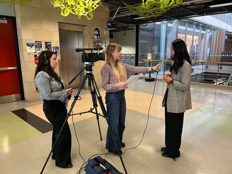 A woman filming an interview between a Journalism student and Public Health resident in the Rogers Communication Centre