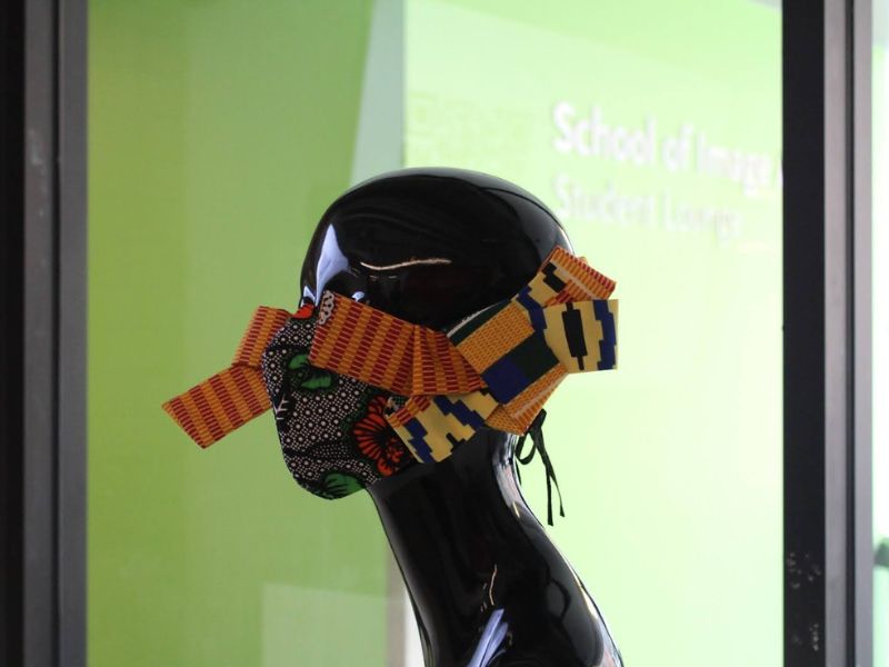 Mannequin head wearing a coloured and patterned bowtie sculpted mask 