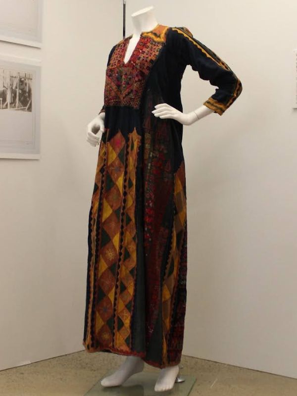 Mannequin wearing a cross-stitch, applique patchwork, and embroidered Palestinian Thobe in colours orange, red, black