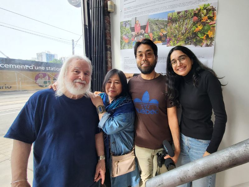 Four artists smile for a picture on a staircase.