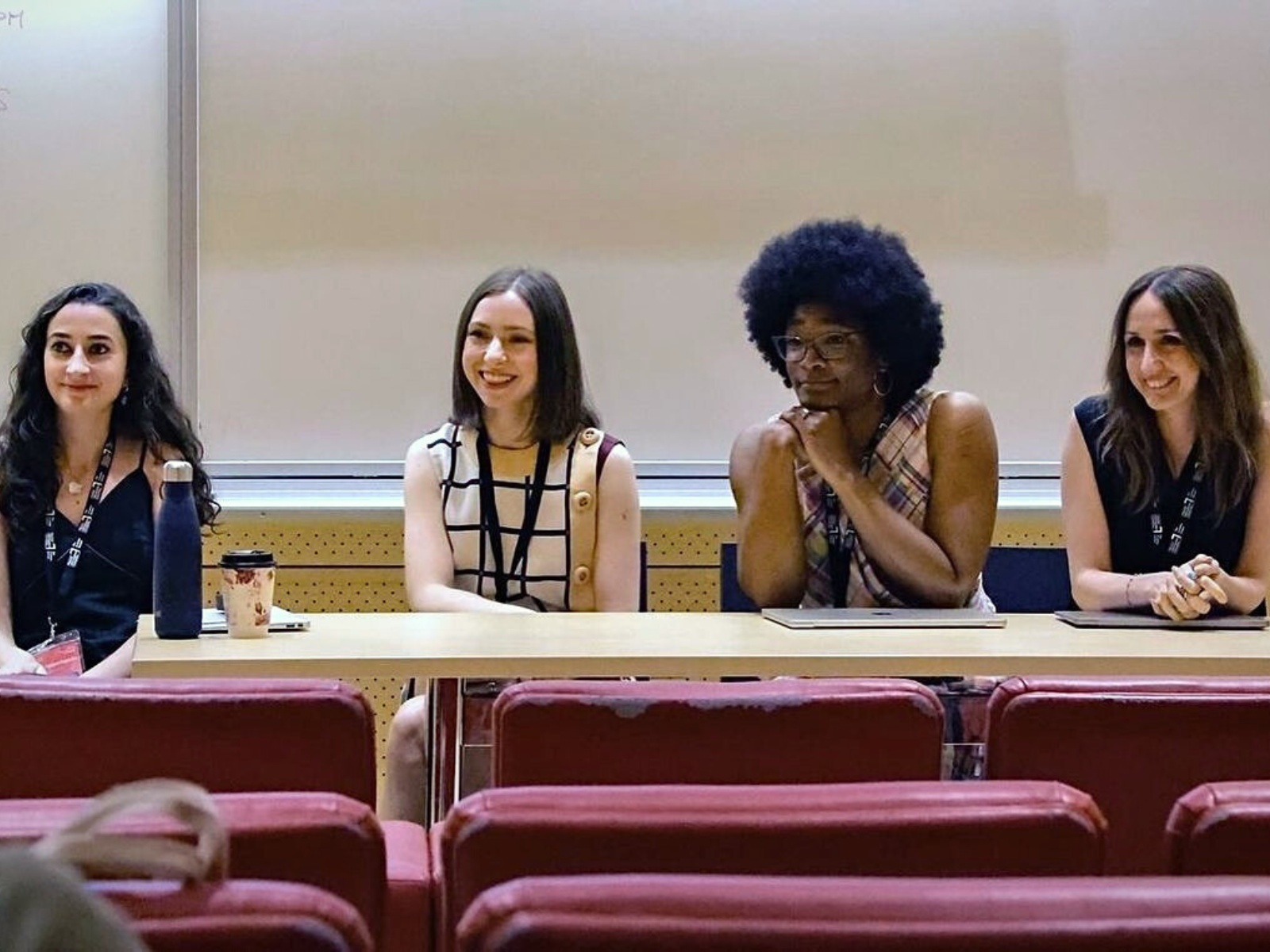 Panelists staring off-camera at an speaker from the audience