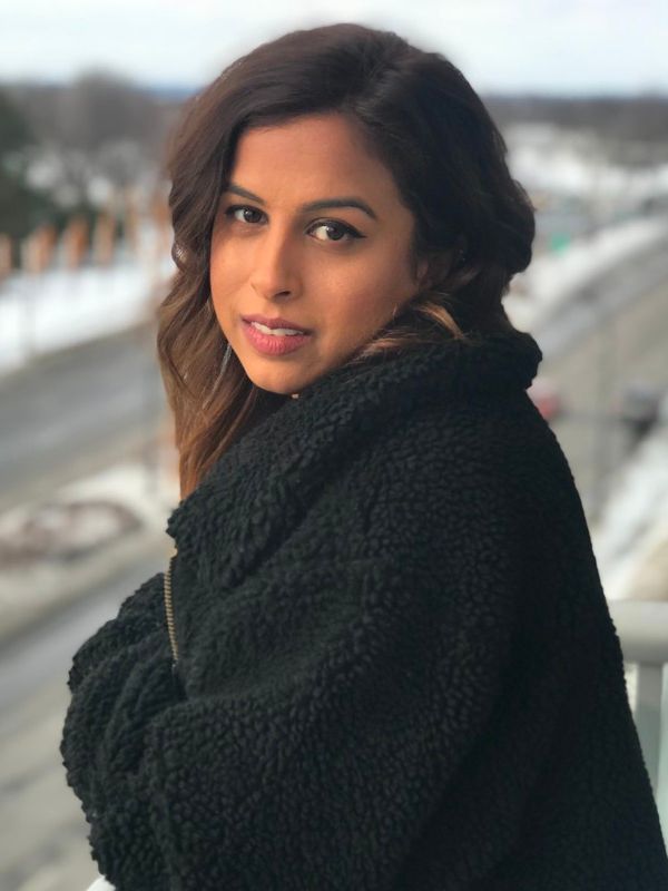 Chantele Sitaram headshot. She has medium dark brown hair and wearing a black jacket 