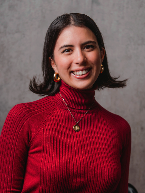 Girl with blakc hair and a red top smiling.