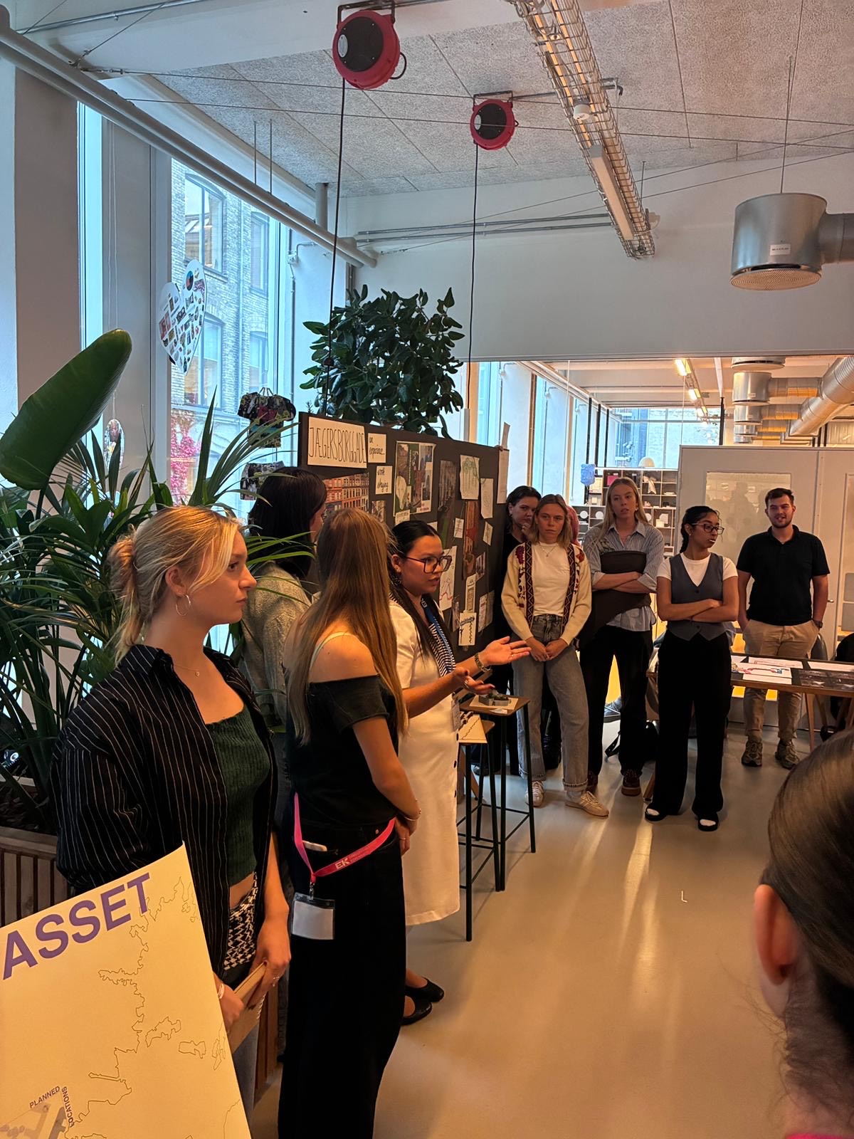 Students gathered around as a participant speaks during presentations at the Art of Keeping: Sustainability through Care and Maintenance design intensive in Copenhagen.