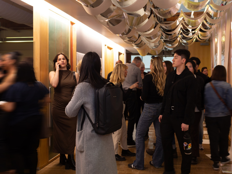 Exhibition attendees stand under a ceiling and wall installation