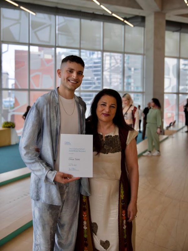 Omar Taleb standing next to a woman holding up his award at the SLC building 