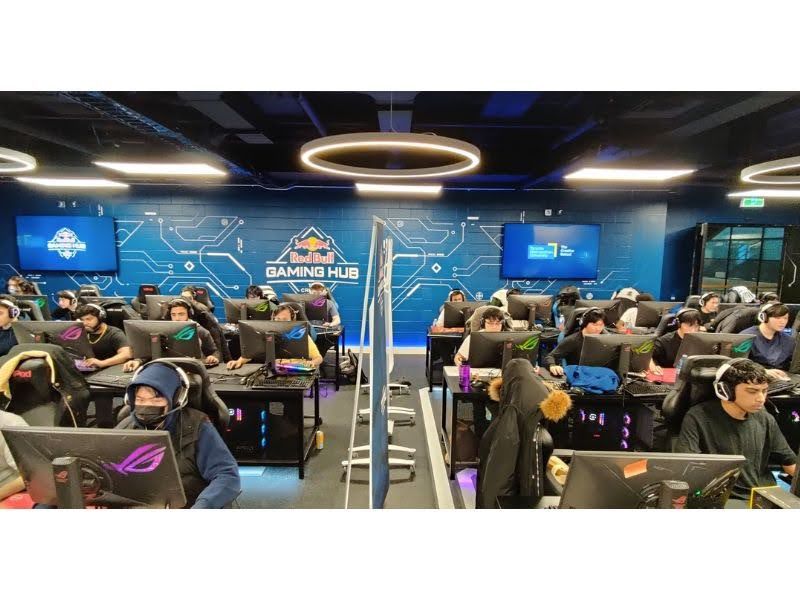 Students in gaming classroom wearing headphones and looking at computer screens