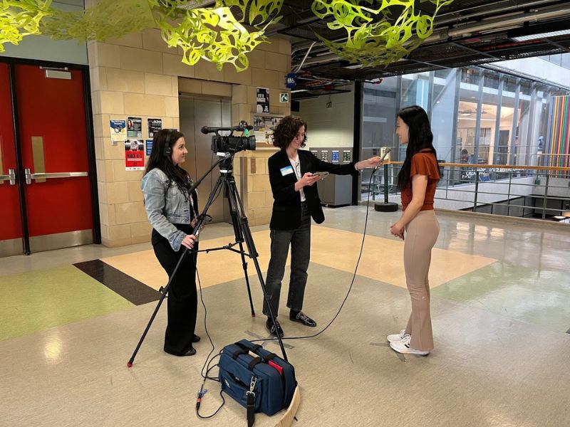 A woman filming an interview between a Journalism student and Public Health resident in the Rogers Communication Centre