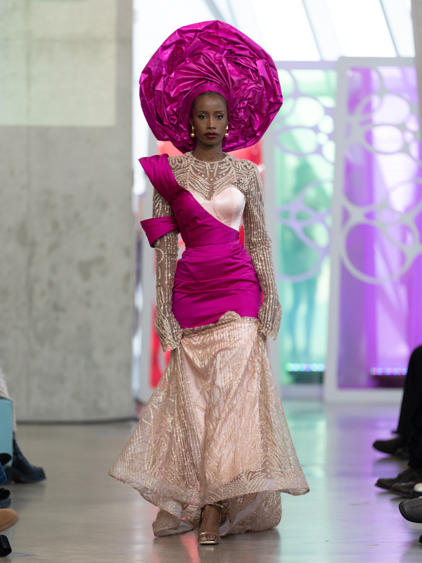 Woman in pink outfit with headpiece.