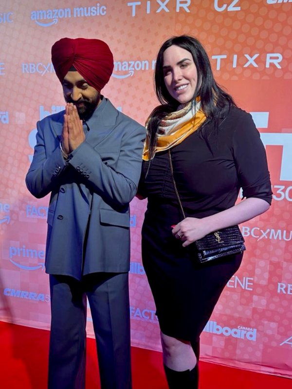 Diljit Dosanjh standing next to Charlie Wall Andrews on a red carpet at the Billboard Canada Summit at NXNE